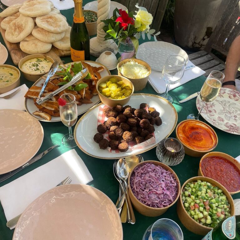 Long-table spread of dips and pita at a private gathering